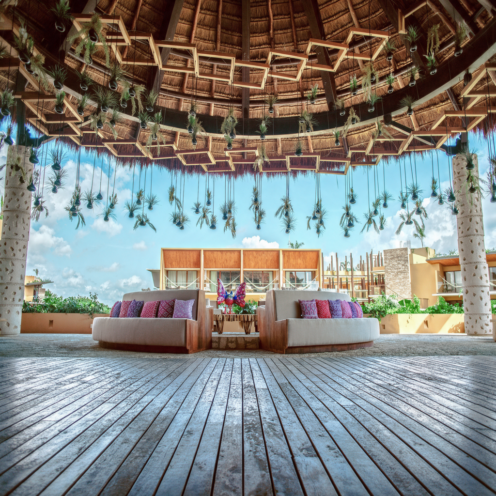 Lounge bajo palapa en hotel de playa con mobiliario artesanal mexicano – La Silla Acapulco